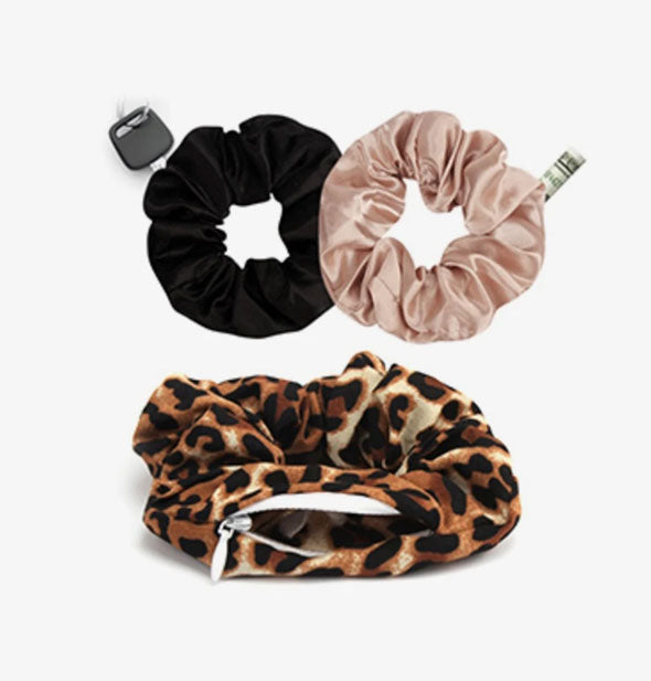 Set of three scrunchies with storage pockets in leopard print, black, and pink fabrics