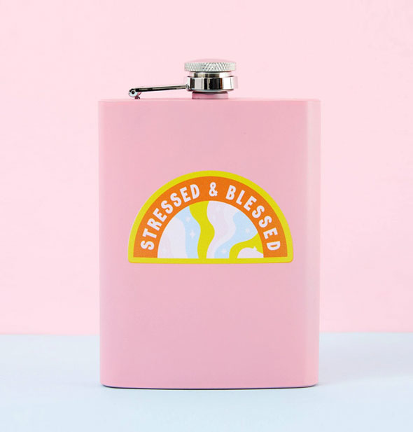 Rectangular pink flask with steel cap says, "Stressed & Blessed" in an arced shape