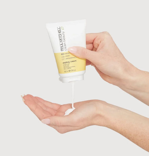 Model dispenses Paul Mitchell Clean Beauty Styling cream from bottle into hand