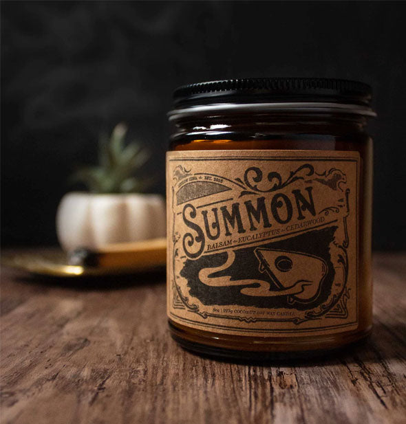 Summon candle jar on wooden tabletop in moody lighting