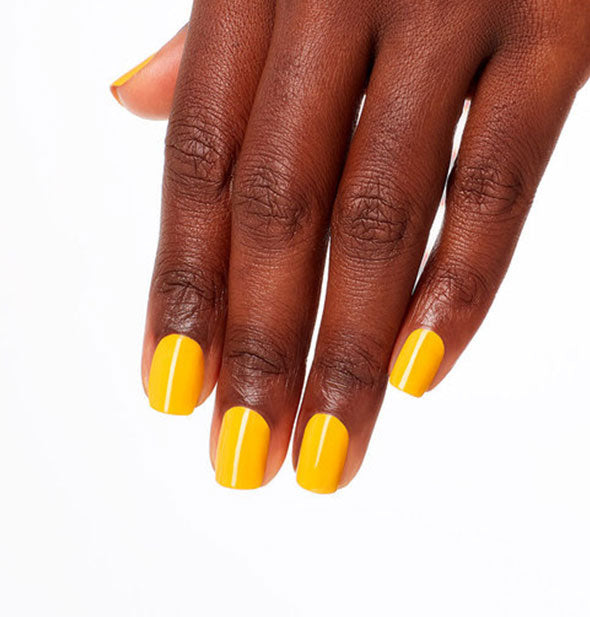 Model's hand wears a bright yellow shade of nail polish