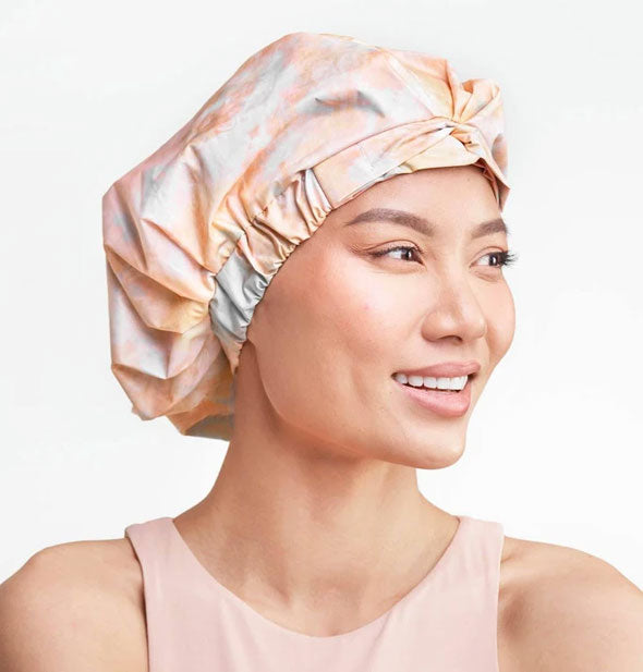 Model wears a tie dye print shower cap with ruched band