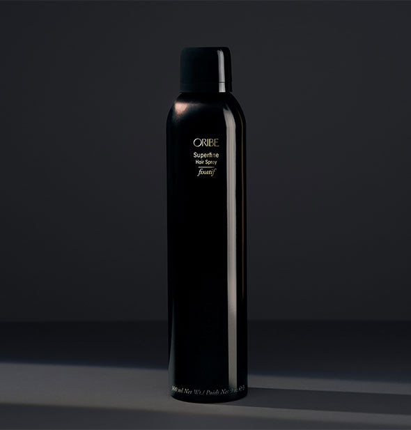 Black can of Oribe Superfine Hair Spray on dark gray background