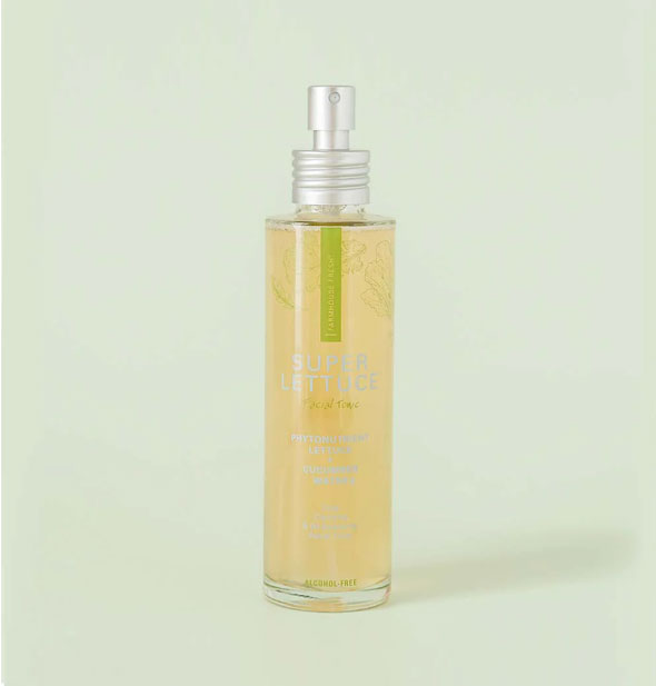Bottle of gold-colored Super Lettuce face mist with a green stripe accent and silver spray nozzle