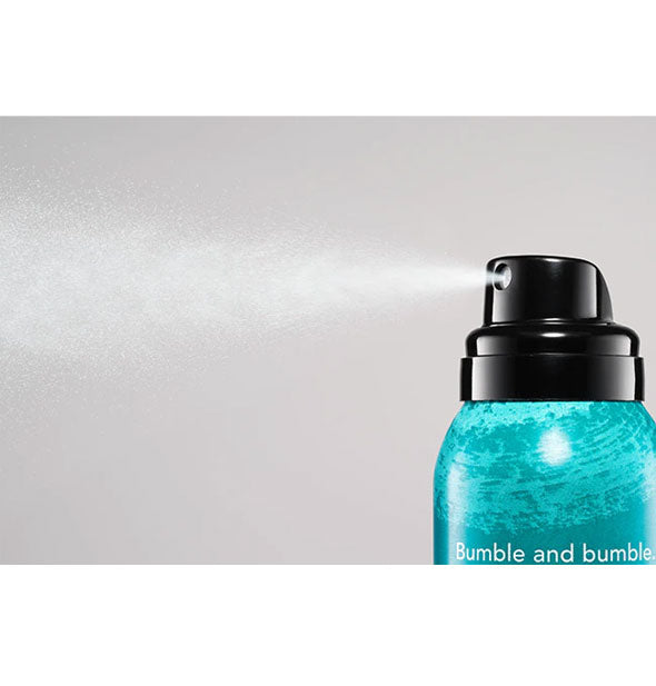 A fine mist is dispensed from a Bumble and bumble product can