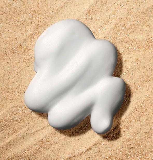 Sample dollop of 5.1 ounce can of Bumble and bumble Surf Wave Foam mousse on a sandy surface