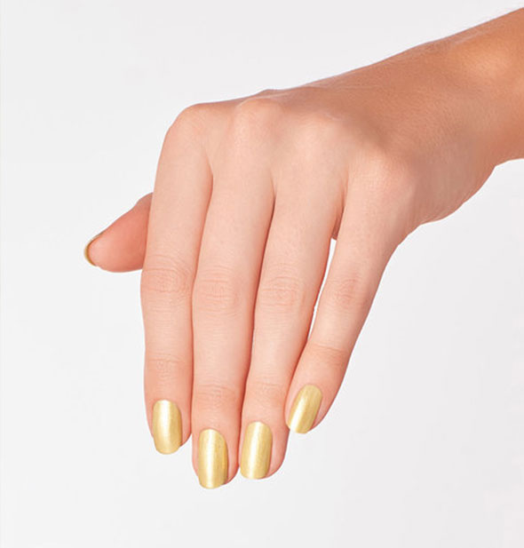 Model's hand wears a shimmering yellow-gold shade of nail polish