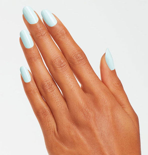Model's hand wears a light sea foam shade of nail polish