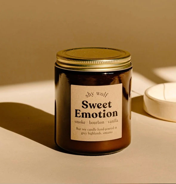 Sweet Emotion candle by Shy Wolf on a light surface with hard shadow