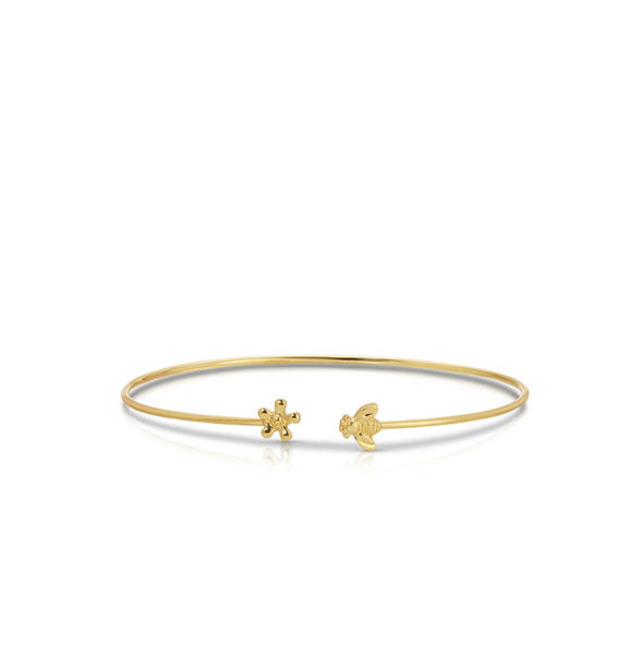 Thin gold cuff-style bracelet with flower and bee charms on each open end
