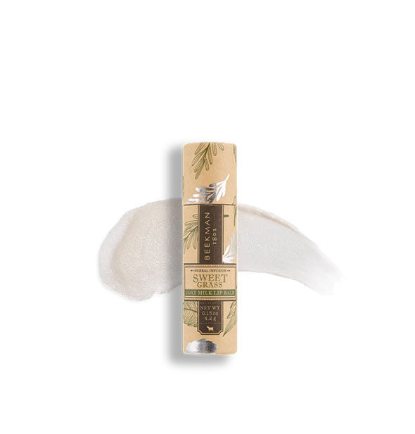 Decorative peach and silver tube of Beekman 1802 Sweet Grass lip balm with sample product application behind