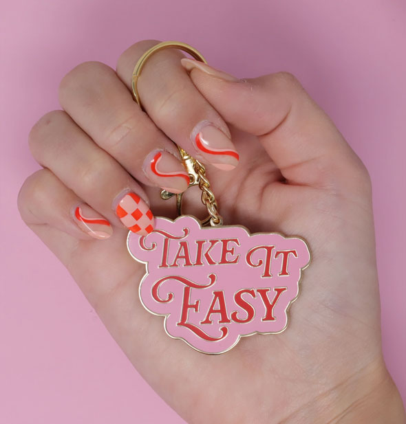 Model's hand holds the Take It Easy keychain for size reference