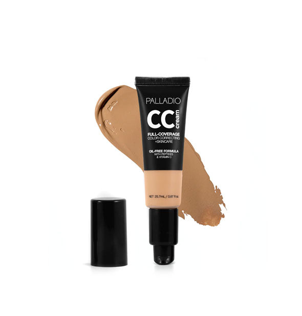 Tube of Palladio CC Cream Full-Coverage Color Correcting +Skincare in a medium-dark shade with cap removed sample swatch behind