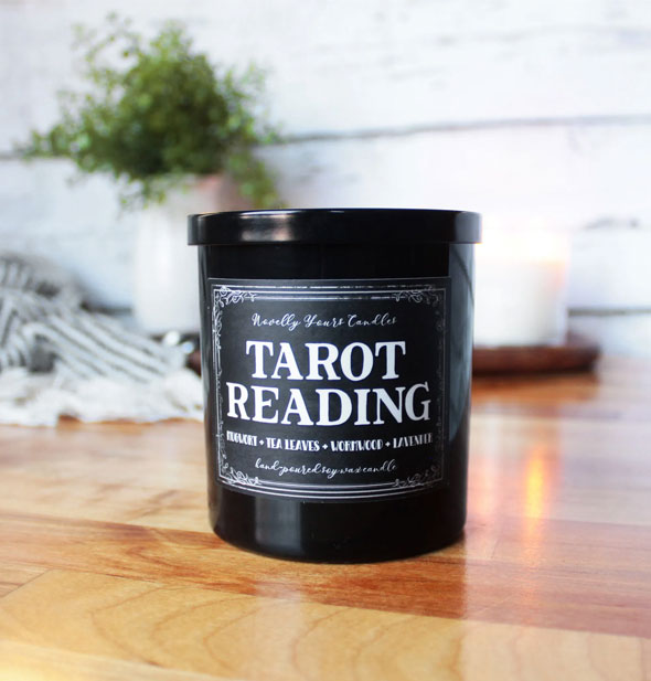 Black jar Tarot Reading candle on wooden tabletop