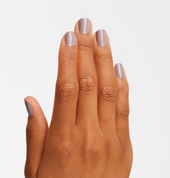Model's hand wears a grayish-purple shade of nail polish