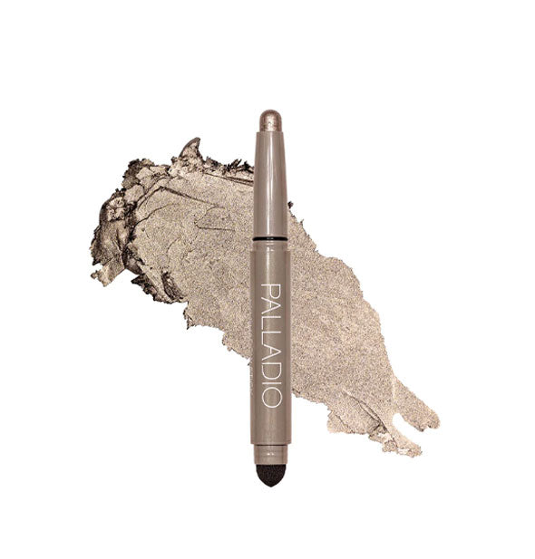Double-ended Palladio eyeshadow stick with color at one end and black blending sponge at the other rests in front of a color swatch sample in the shade Taupe Shimmer
