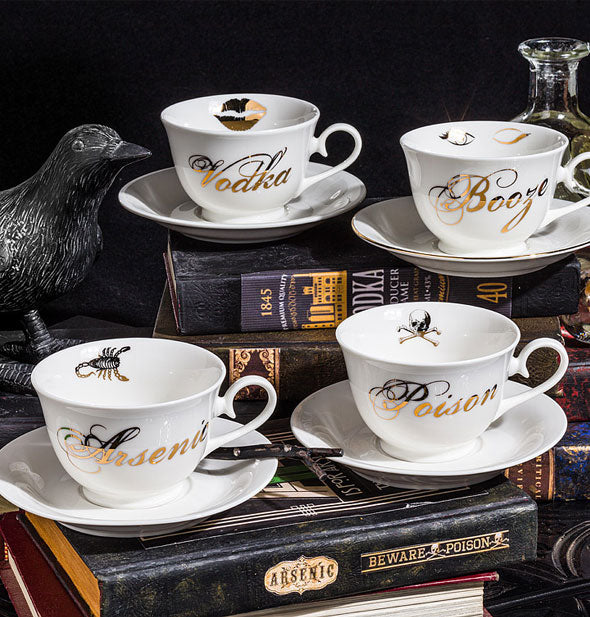Grouping of four teacups and saucers: Vodka, Booze, Arsenic, and Poison