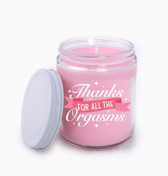 Pink wax candle in clear glass jar with white lid says, "Thanks for All the Orgasms" in alternating fonts with banner graphic
