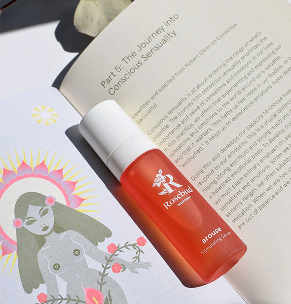 Open page of Chapter 5 of The Invitation with a bottle of Rosebud Woman Arouse Stimulating Serum resting in the crease