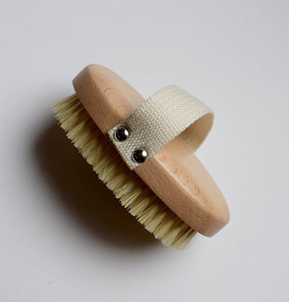 Side view of a beech wood hand brush with cotton strap