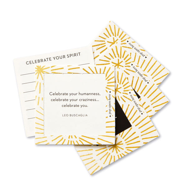 Stack of square cards with gold accents features topmost card printed with a Leo Buscaglia quote: "Celebrate your humanness, celebrate your craziness...celebrate you." Another card says, "Celebrate your spirit"