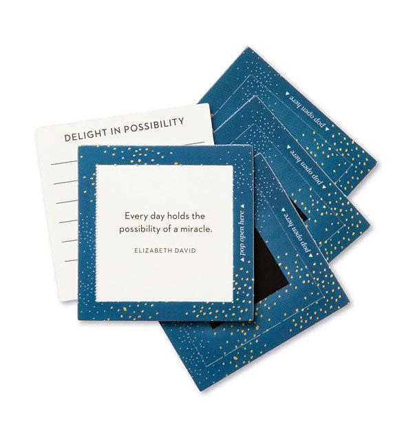 Stack of blue square cards with gold speckle pattern features topmost card printed with an Elizabeth David quote: "Every day holds the possibility of a miracle." Another card says, "Delight in possibility"