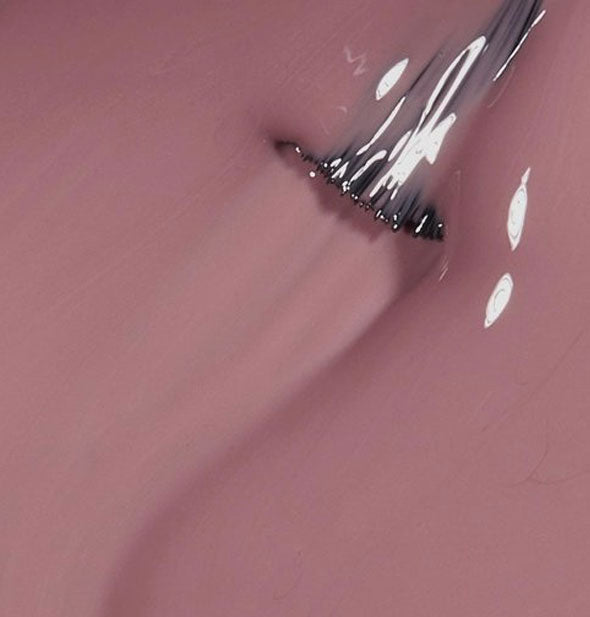 Rosy brown nail polish with brush tip drawn through it