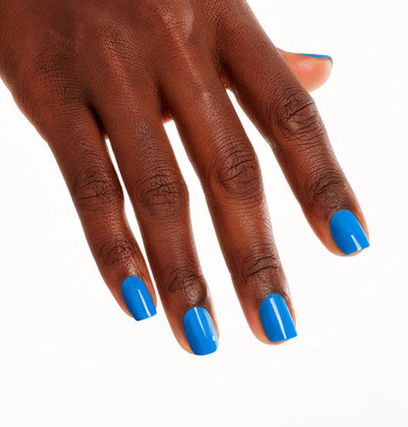 Model's hand wears a bright blue shade of nail polish