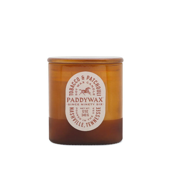 Amber-colored Tobacco & Patchouli Paddywax candle jar with oblong tex-heavy pale pink label