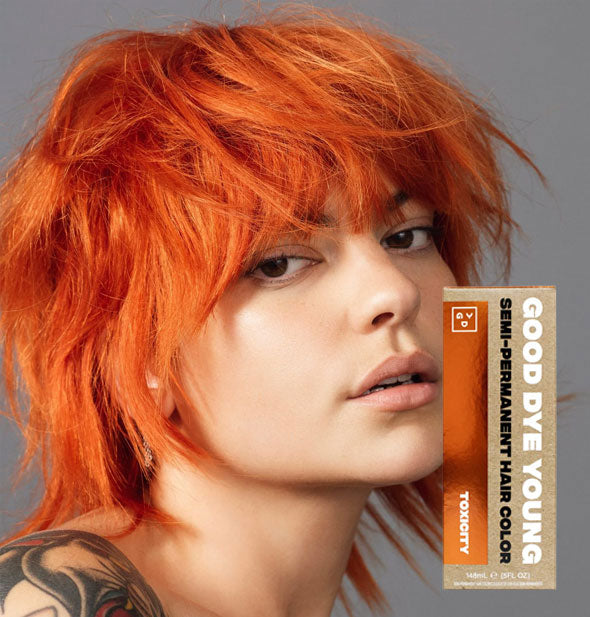 Model with bright orange hair color by Good Dye Young in the shade Toxicity