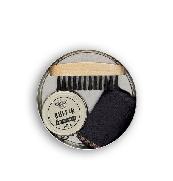 Contents of the Travel Shoe Shine Kit packed inside a round tin: brush, polish, and cloth