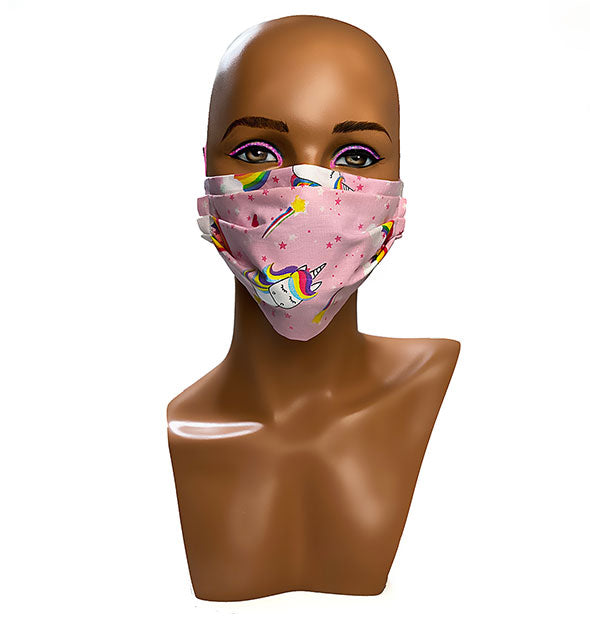 A mannequin head wears a pink unicorn cartoon patterned face mask