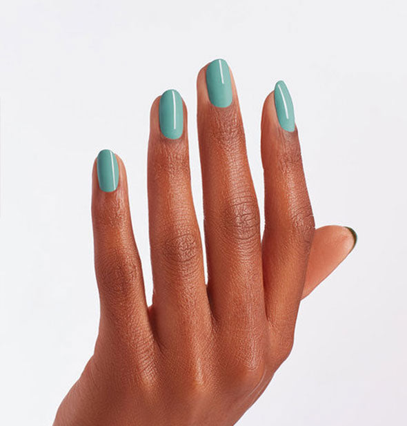 Model's hand wears a teal shade of nail polish