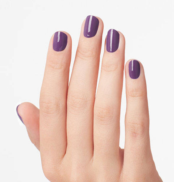 Model's hand wearing purple nail polish