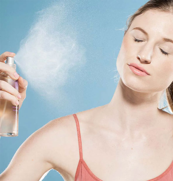Model mists face with a spritz from a bottle of Vitamin Berry Facial Tonic