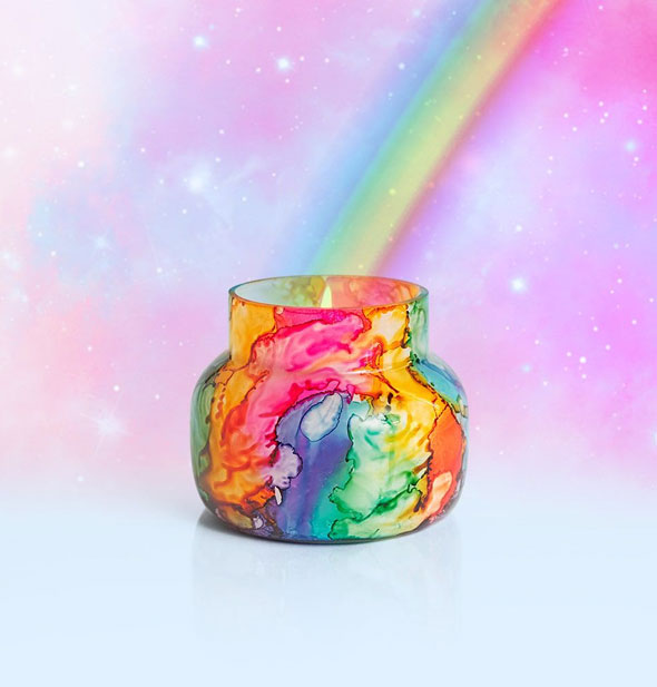 Colorful watercolor-effect jar candle on a starry background with rainbow emanating from its flame within