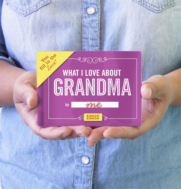 Model poses with a copy of What I Love About Grandma for size reference