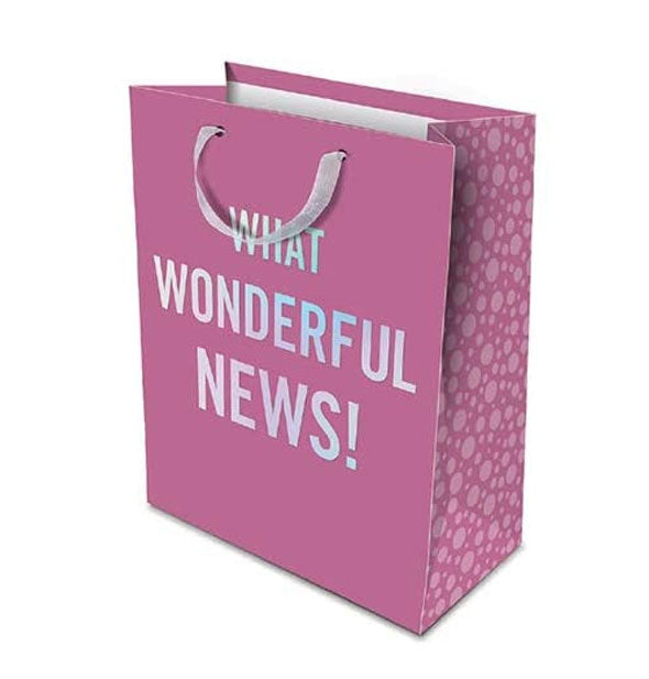 Pinkish-purple gift bag with patterned side panel says, "What wonderful news!" in large iridescent lettering