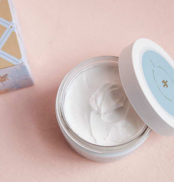 Opened jar of Lollia body butter shows creamy white product inside