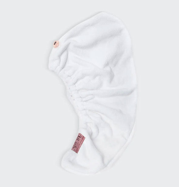 White microfiber hair towel wrap by Kitsch lays flat to show button closure and elastic opening