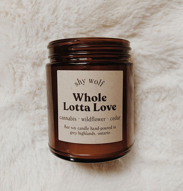 Amber glass jar Whole Lotta Love candle on white fur background