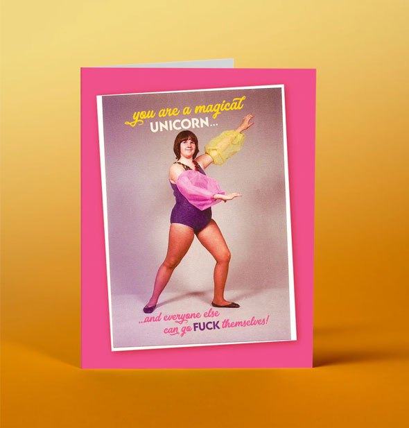 Greeting card with pink border features a retro photograph of a posing dancer wearing a purple leotard with puffy pink and yellow arm accessories and the message, "You are a magical unicorn...and everyone else can go FUCK themselves!"