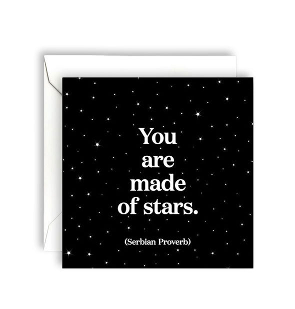Square black greeting card with celestial pattern and accompanying envelope is printed in white lettering with a Serbian proverb: "You are made of stars."