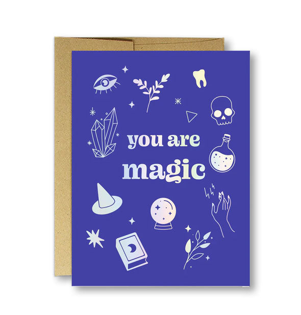 Purple greeting card on top of kraft envelope features "You are magic" holographic lettering with themed illustrations