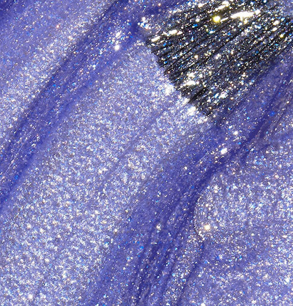 Shimmery blueish-purple nail polish with a brush tip swiped through it