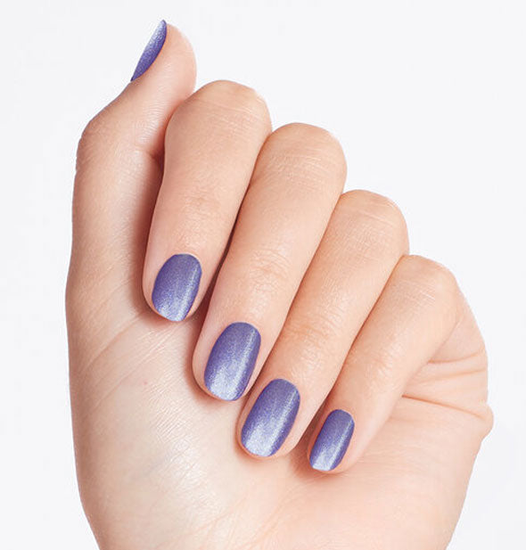 Model's hand wearing a pearlescent blue shade of nail polish