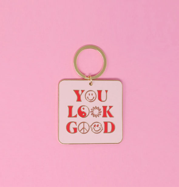 Light pink square keychain with rounded corners on gold ring says, "You look good" with smiley faces, sun, peace sign, and yin yang symbol in place of the Os