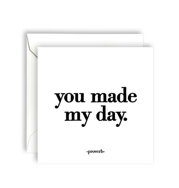 Square white greeting card with envelope is printed in large black lowercase lettering with the proverb, "You made my day."