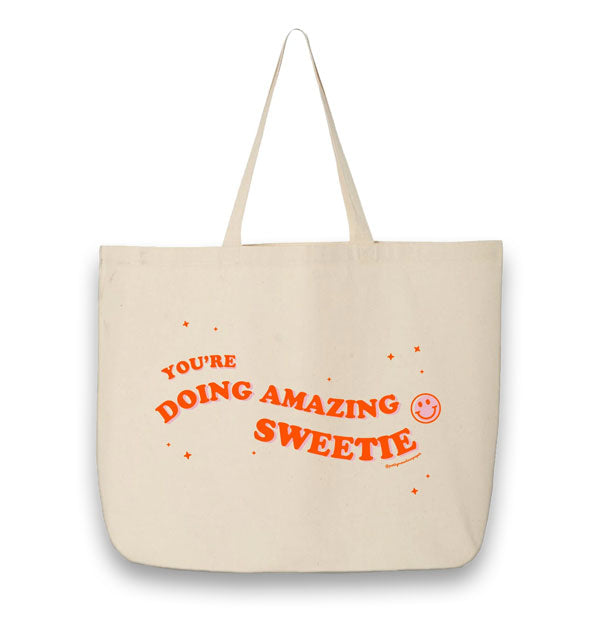 White canvas tote bag says, "You're doing amazing sweetie" in red ink with pink smiley face and star accents
