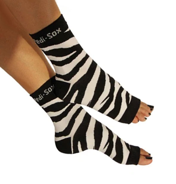 A pair of open-toe zebra print Pedi-Sox socks on a model's feet